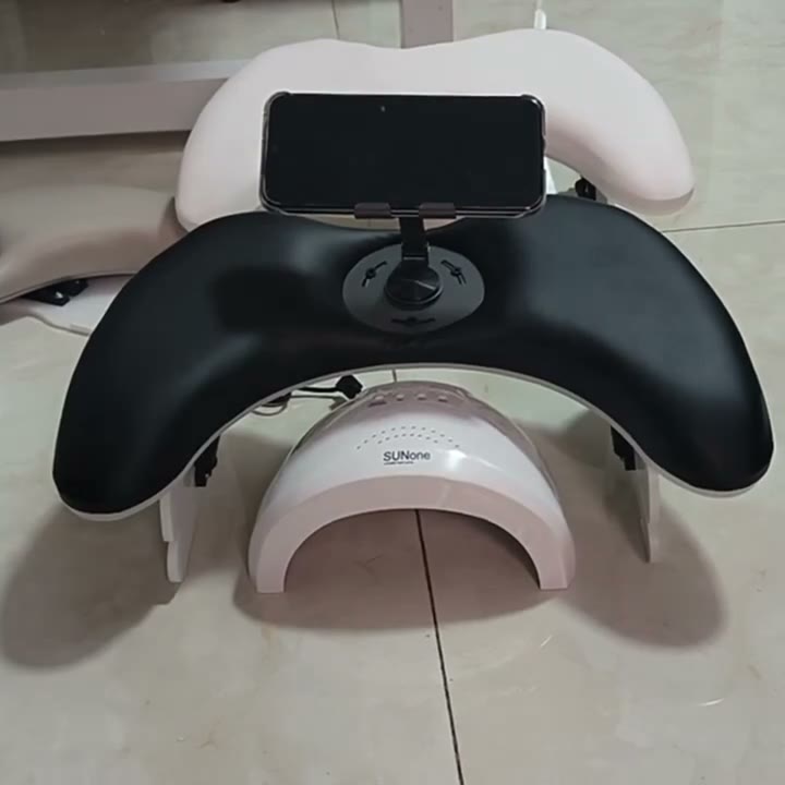 Padded manicure hand rest with a phone clamp and lamp slot